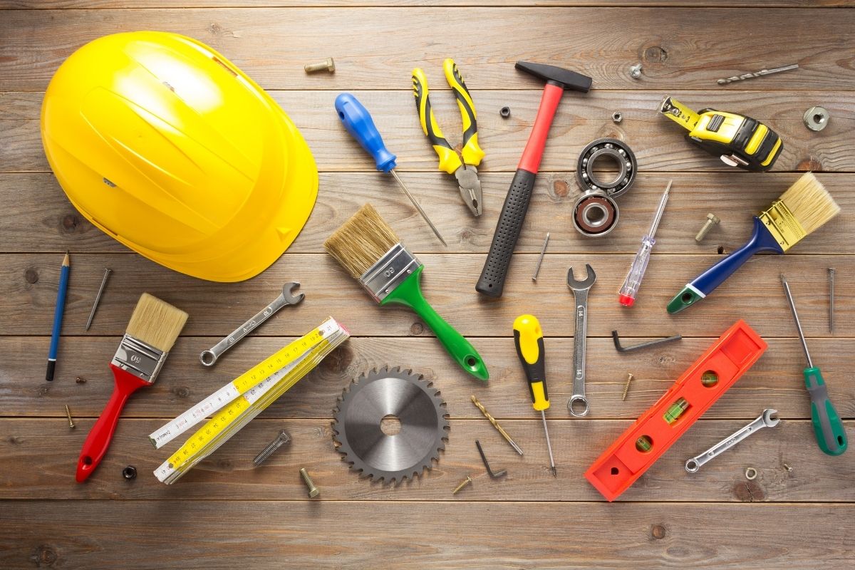 A wooden table displaying various tools and construction supplies, including hammers, screws, and measuring tape.